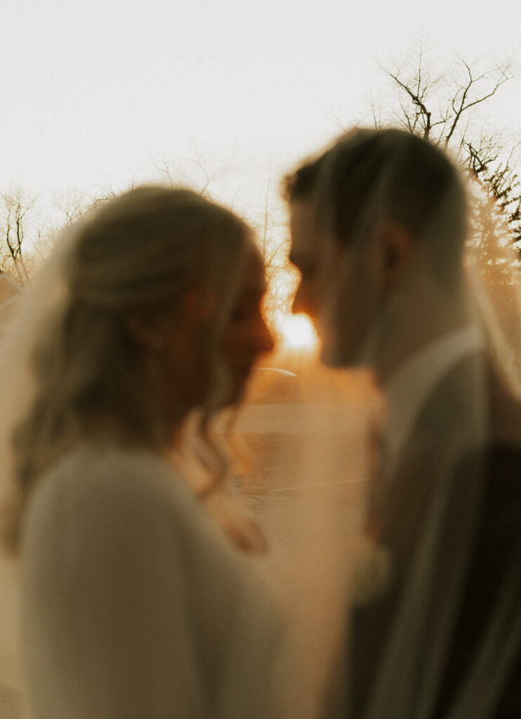 upscale bride and groom portraits outside of historical wedding venue during golden hour under veil photography
