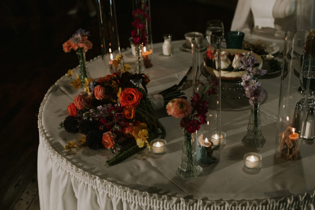unique floral and decorative details on bride and groom table at wedding reception