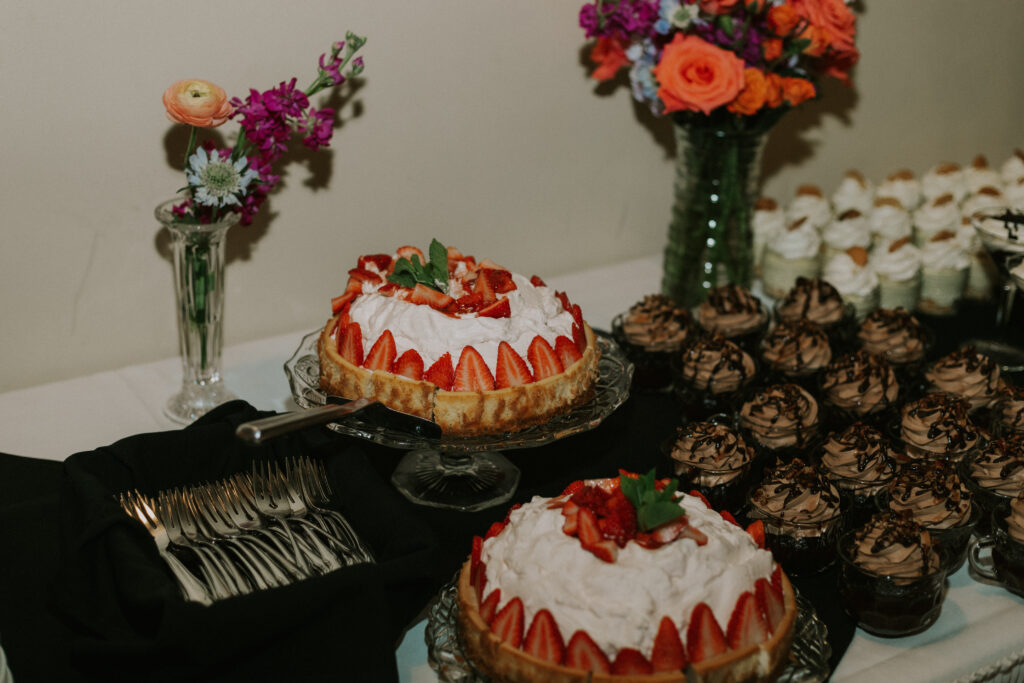 upscale wedding dessert table at wedding reception, cheesecake and cupcakes