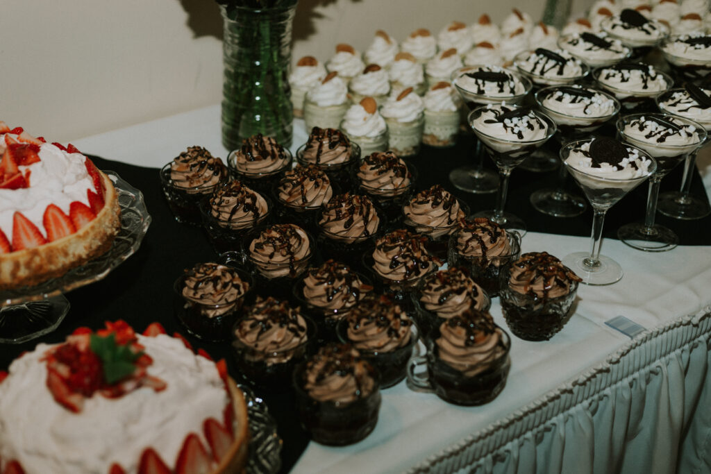 upscale wedding dessert table at wedding reception, cheesecake and cupcakes