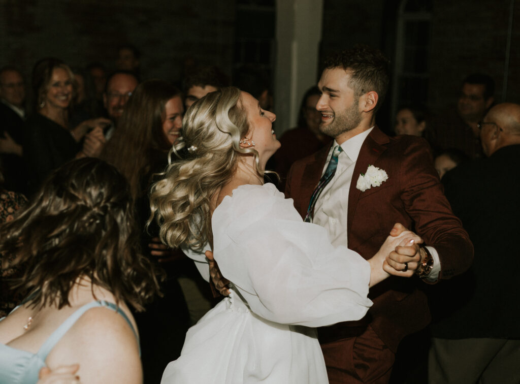 dance floor pictures of bride and groom at wedding reception with sparkling lights and brick wedding venue