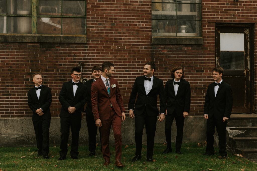 Groomsmen party pictures in front of the historical brick building in downtown Goshen Indiana at Bread & Chocolate