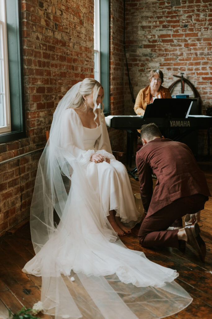 sacred moment during wedding ceremony photographer washing each others feet as Jesus did 