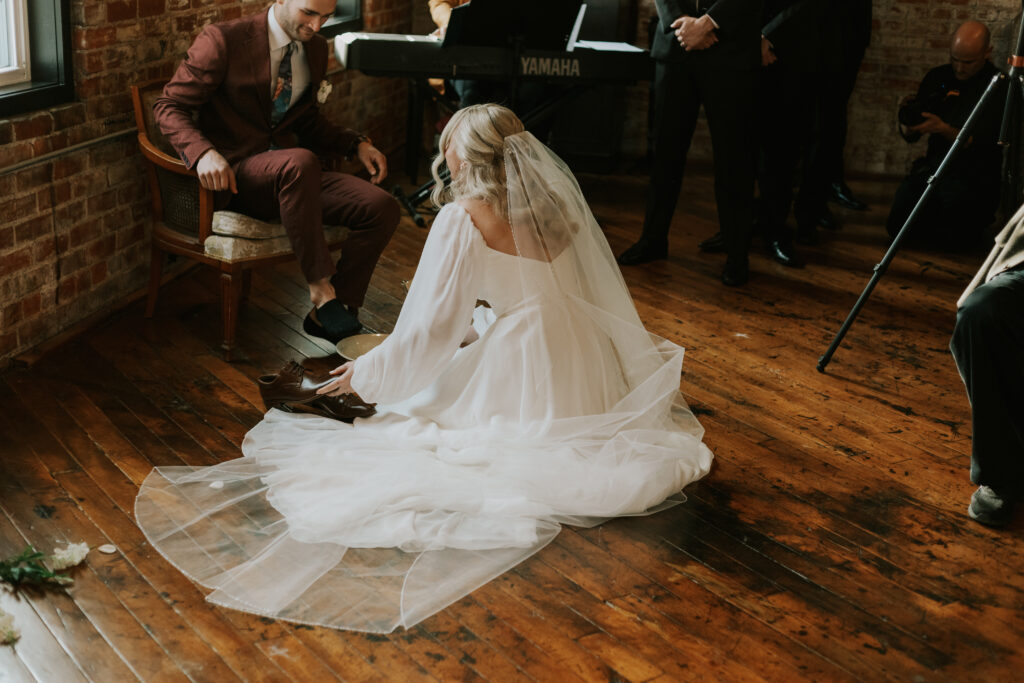 sacred moment during wedding ceremony photographer washing each others feet as Jesus did 