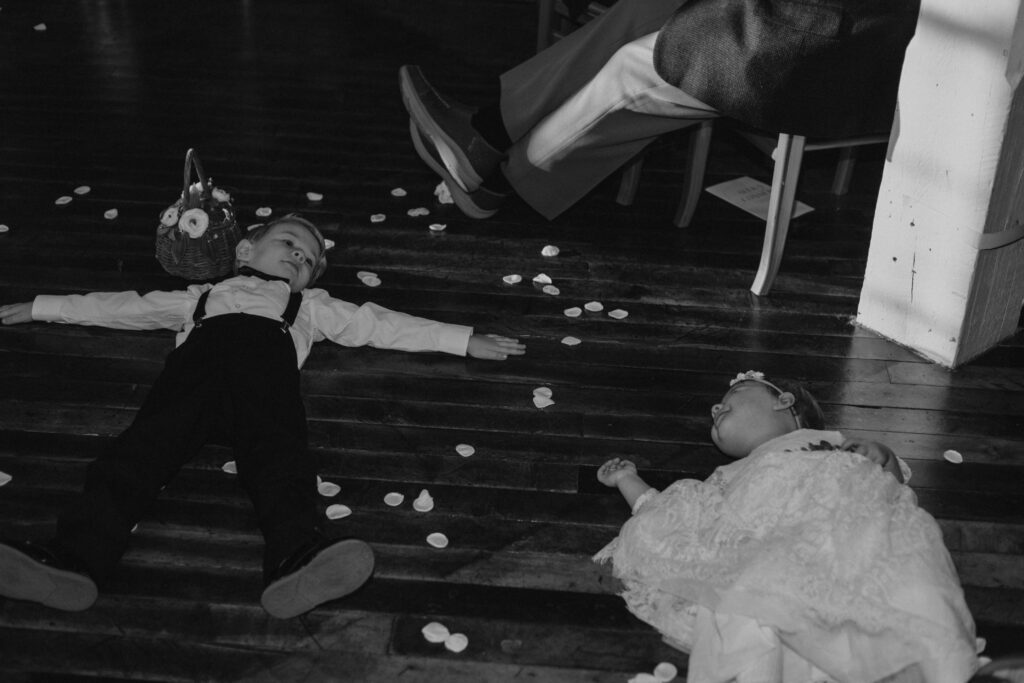 flower girl and ring bearer after ceremony playing with flower petals