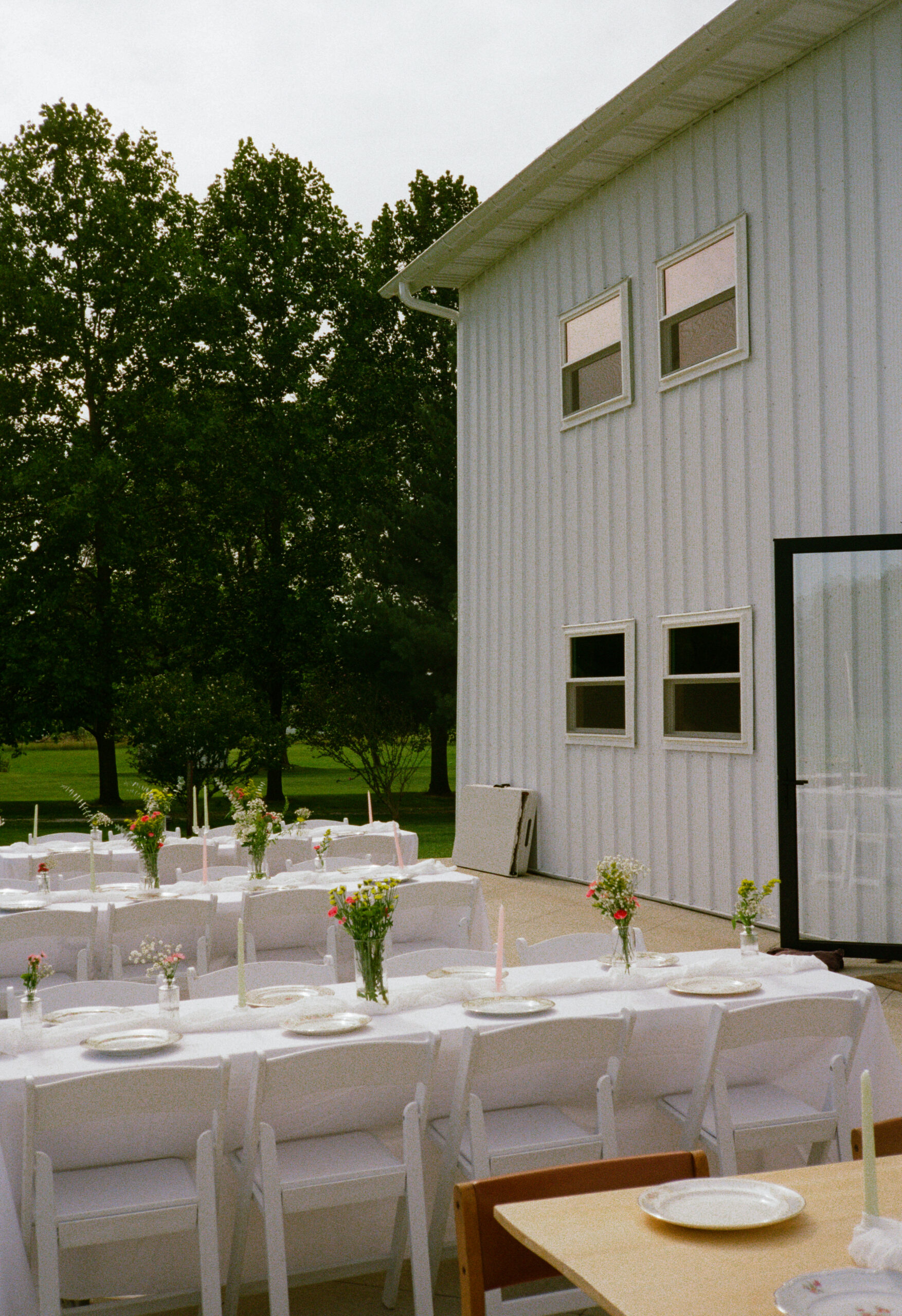 outdoor wedding reception details and decor, flower bud vases, mixed china plates, and tables in warsaw and winona lake indiana.