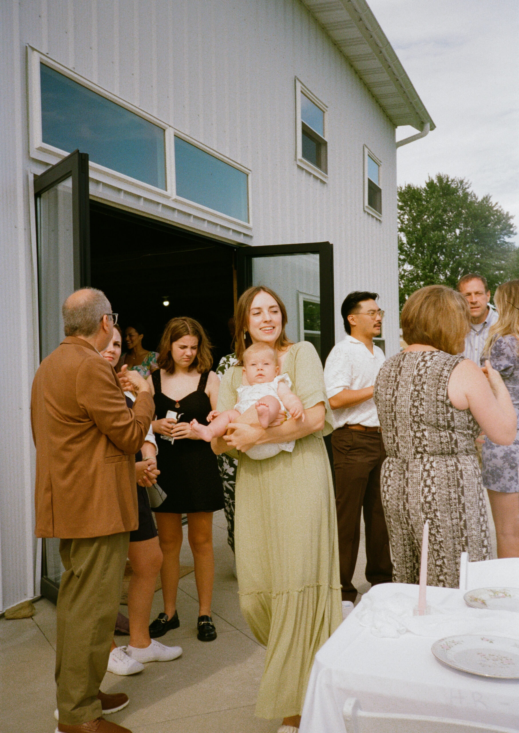 guests eating and talking at outdoor wedding reception in warsaw and winona lake indiana, on 35mm film photography.