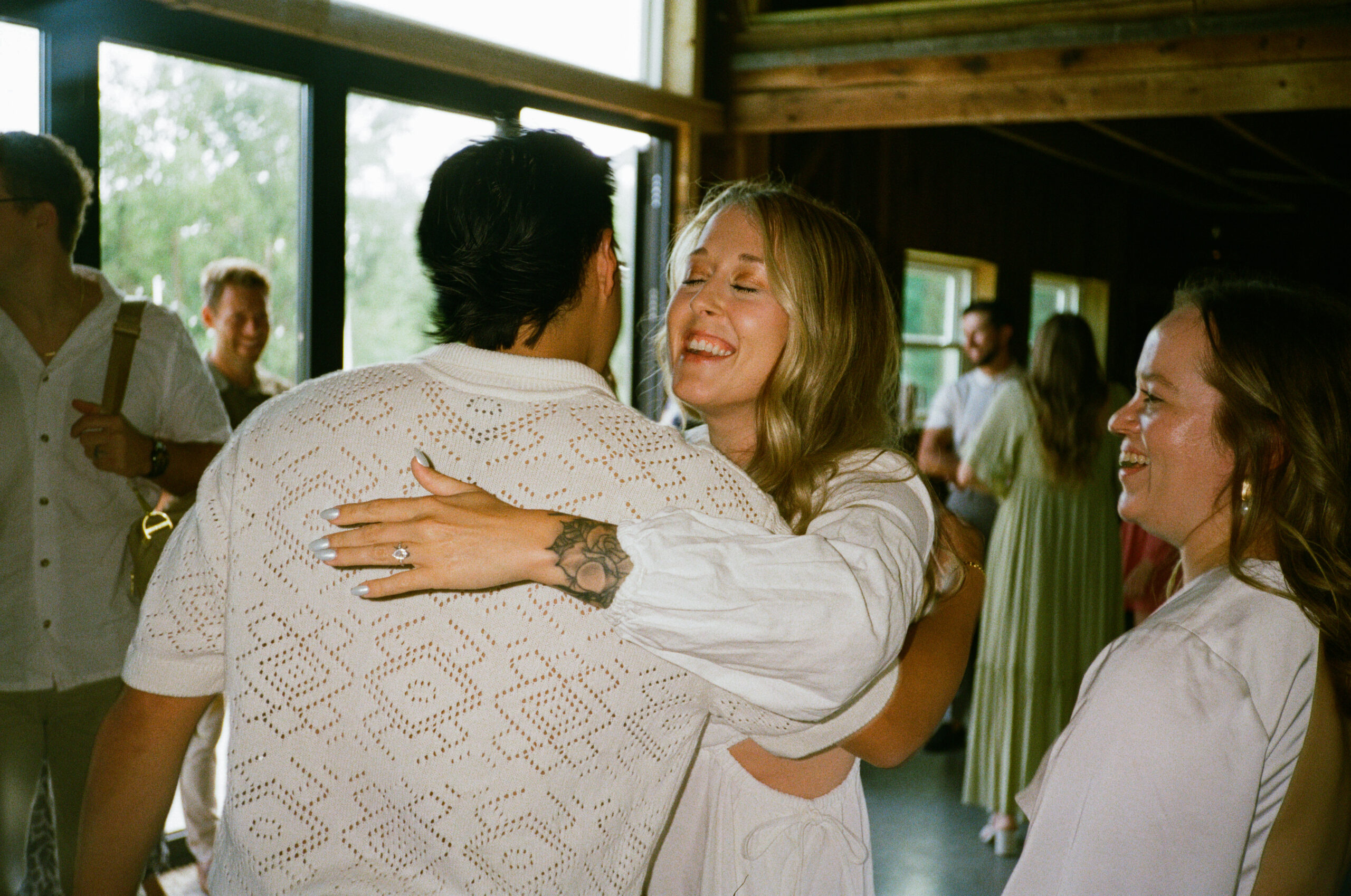 Guests hugging bride and groom at wedding reception in winona lake and warsaw indiana at an outdoor wedding.