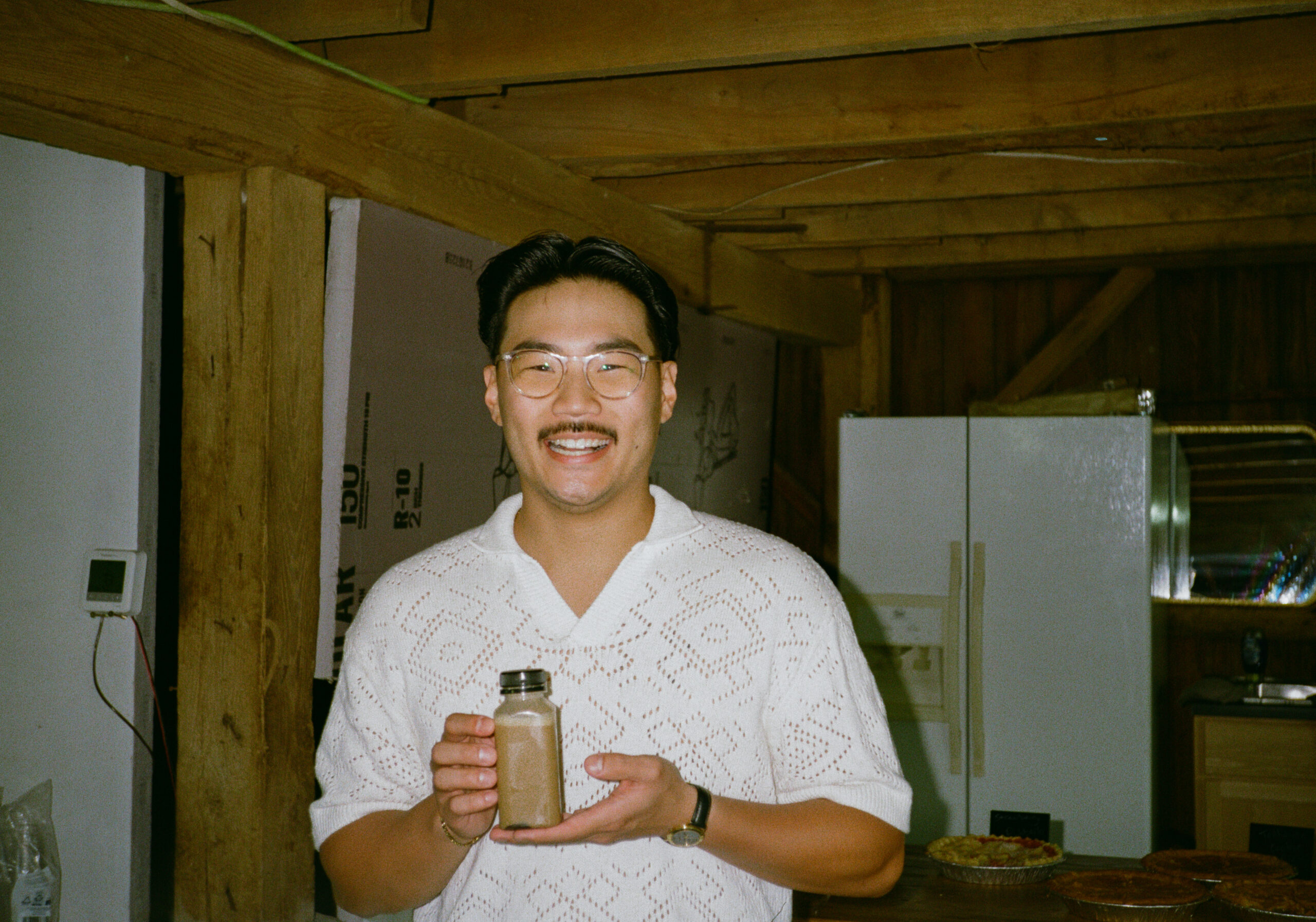The groom holding a homemade chocolate cold brew, which was served to guests at their wedding reception in winona lake and warsaw indiana
