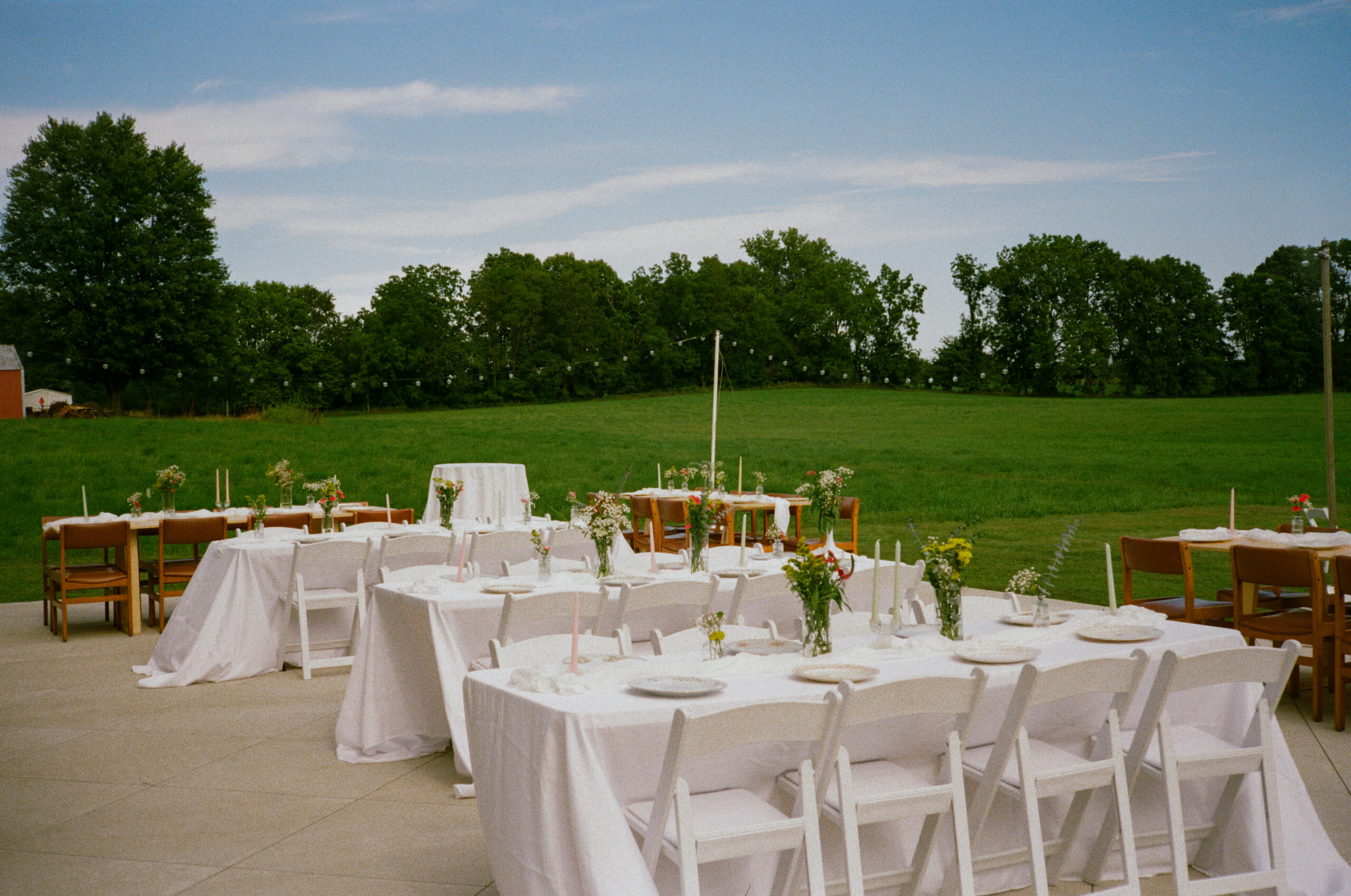 outdoor wedding reception details and decor, flower bud vases, mixed china plates, candle sticks, and tables in warsaw and winona lake indiana.