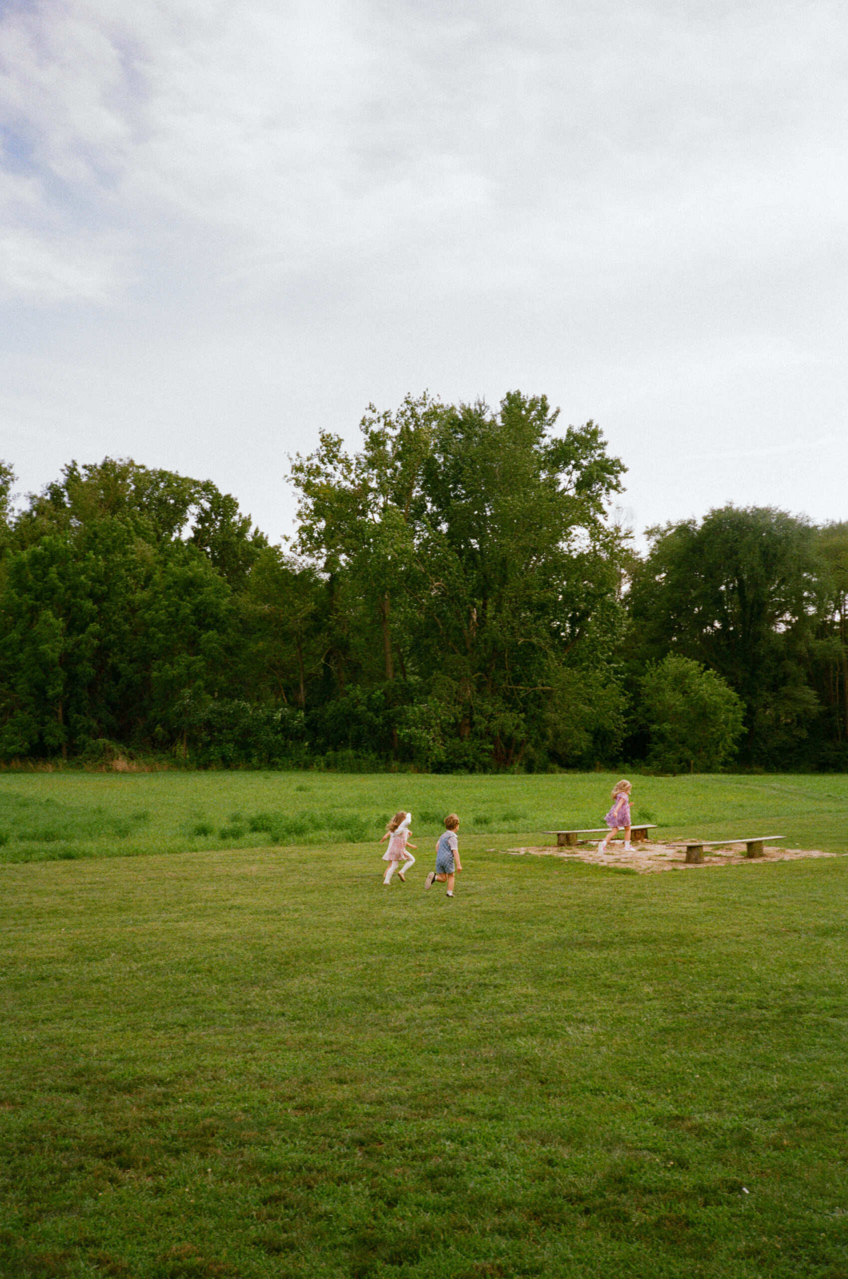 guests and children enjoying the outdoor wedding reception in a field in warsaw and winona lake indiana.