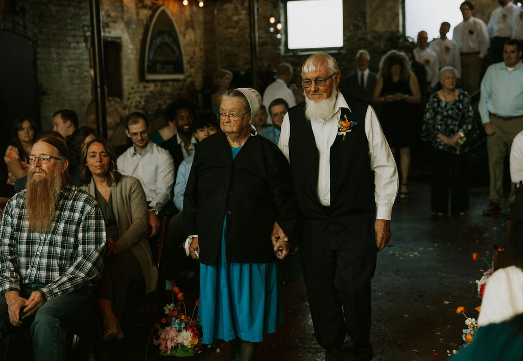 Grandparents walking down to aisle at wedding ceremony to take their seat at Muncie Indiana North Church Wedding Venue.