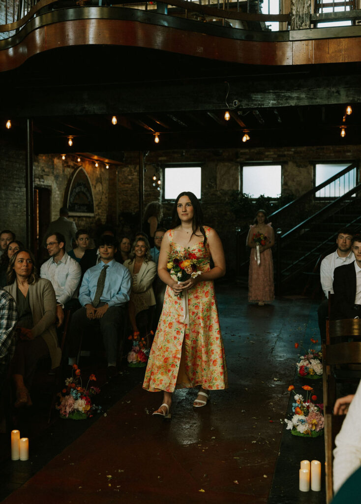 Bridesmaid walking down the aisle at wedding ceremony at North Church Wedding Venue in Muncie, Indiana.