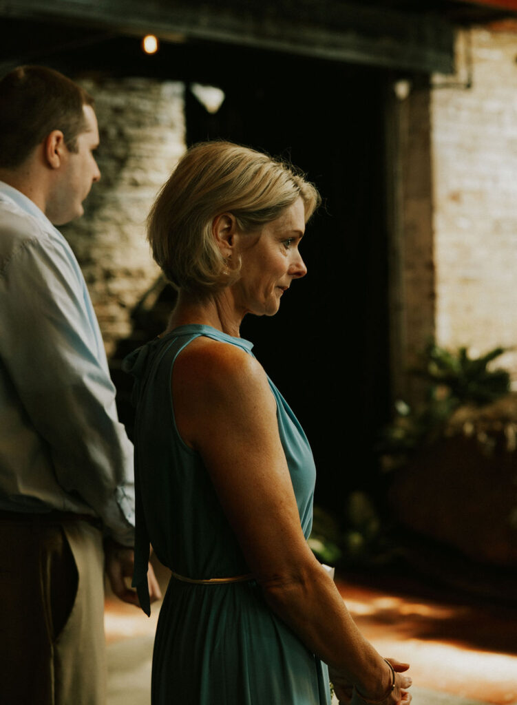 Mother of bride bowing head during prayer at wedding ceremony in Muncie, Indiana at North Church Venue.