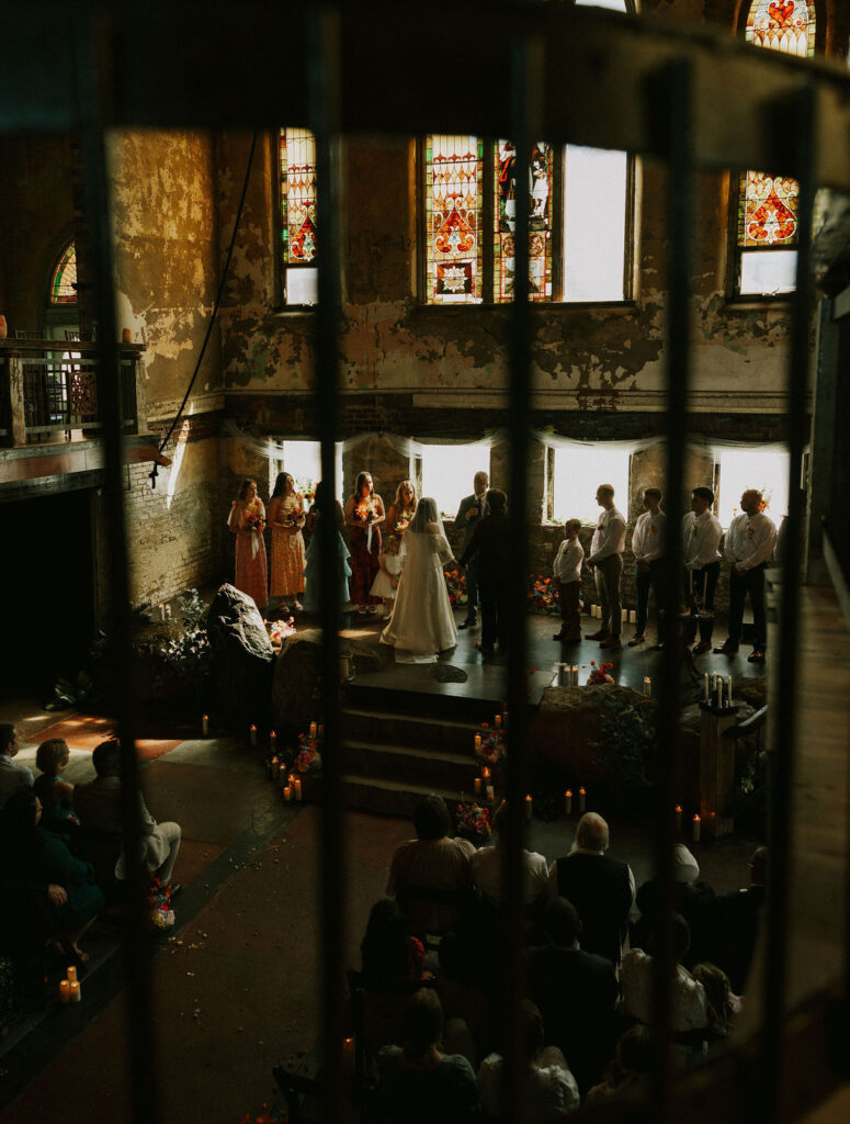 Bride and groom at wedding ceremony on stage from the loft at North Church Venue in Muncie, Indiana.