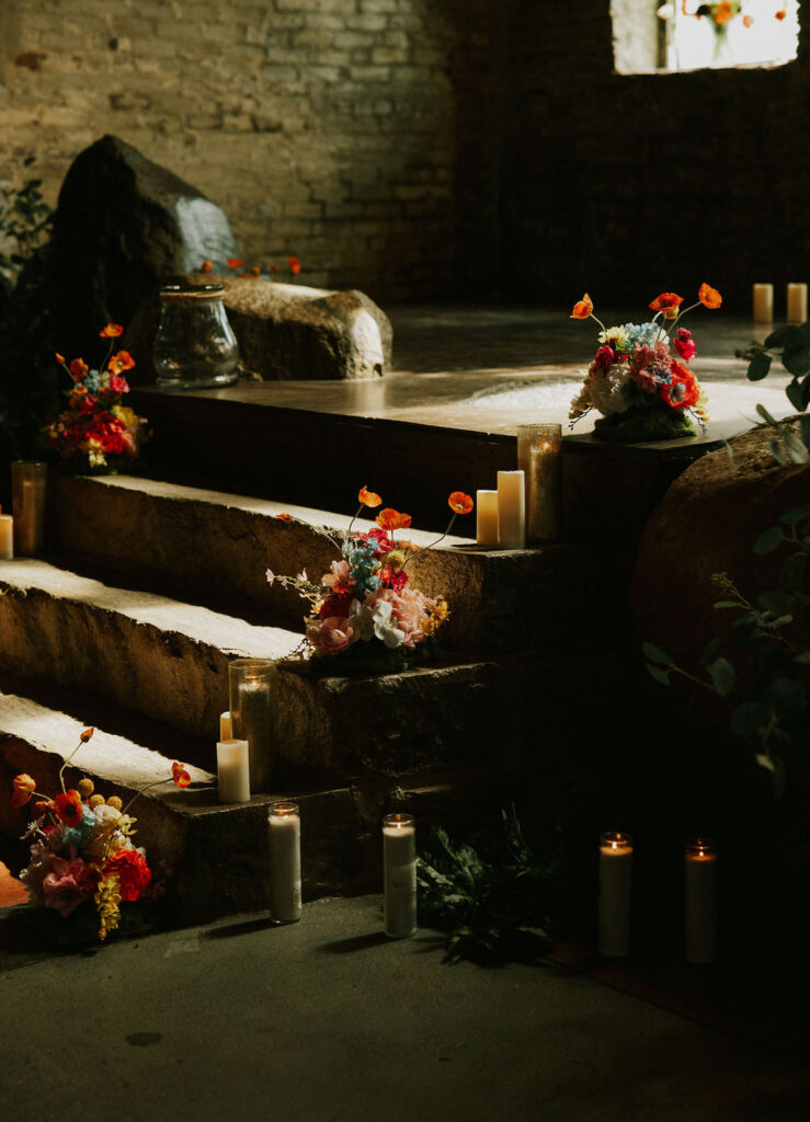 Eclectic wedding florals, colorful bouquets lining a historic stairway in The North Church venue in Muncie, Indiana.