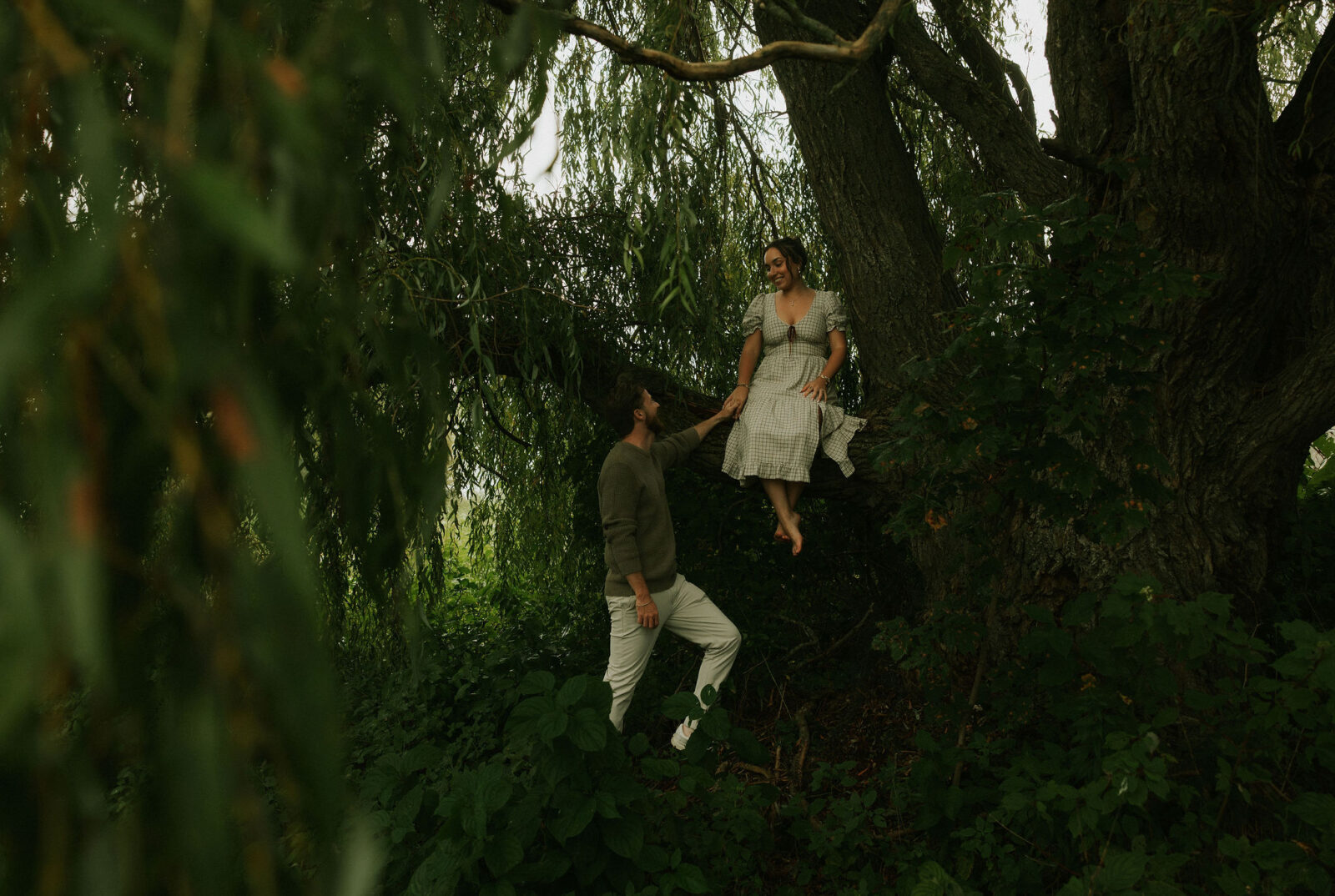 Couple getting engaged on Mackinac Island, Michigan taking couples pictures under a tree.