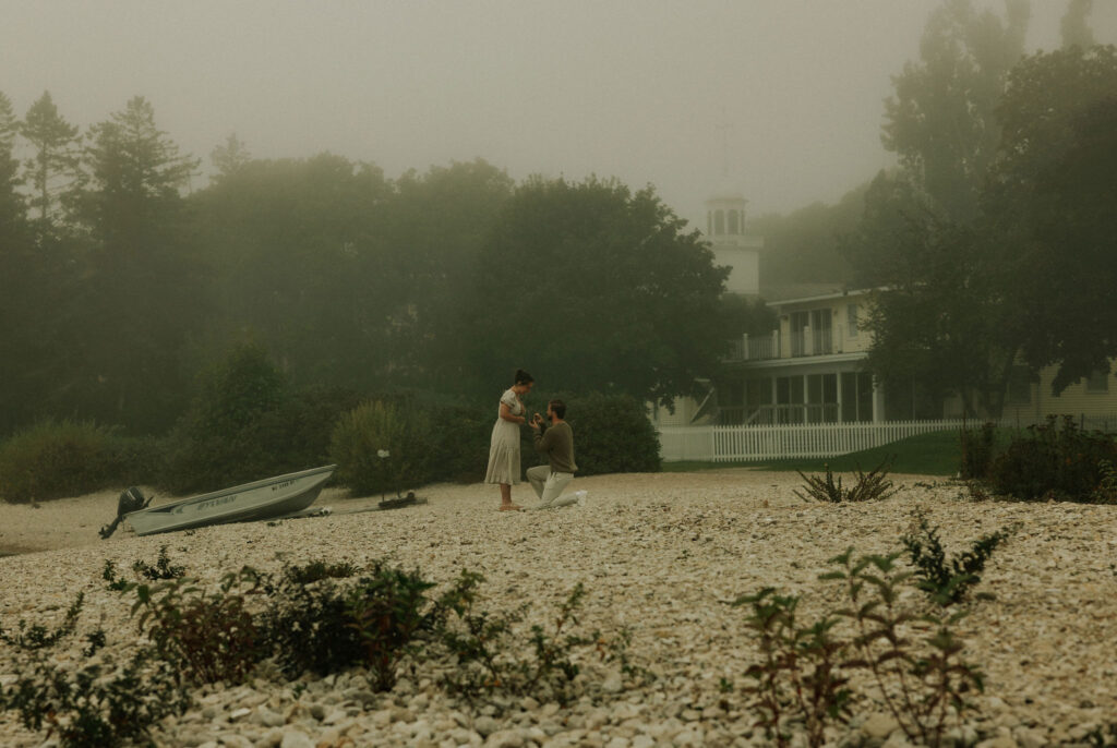 Couple getting engaged on Mackinac Island, Michigan on the beach.