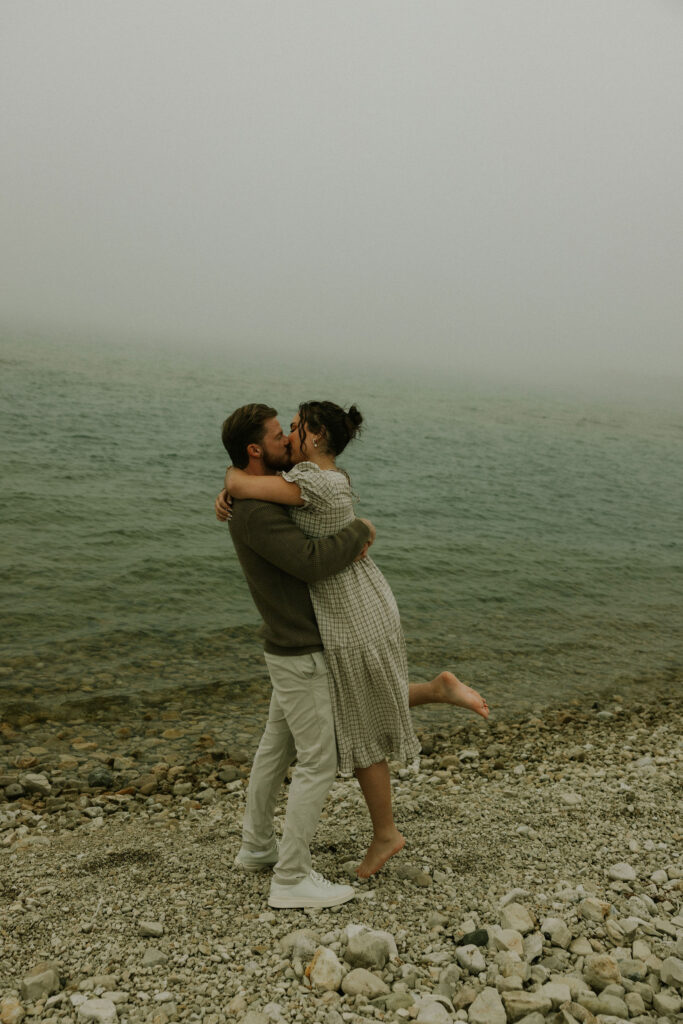 Couple getting engaged on Mackinac Island, Michigan on the beach.