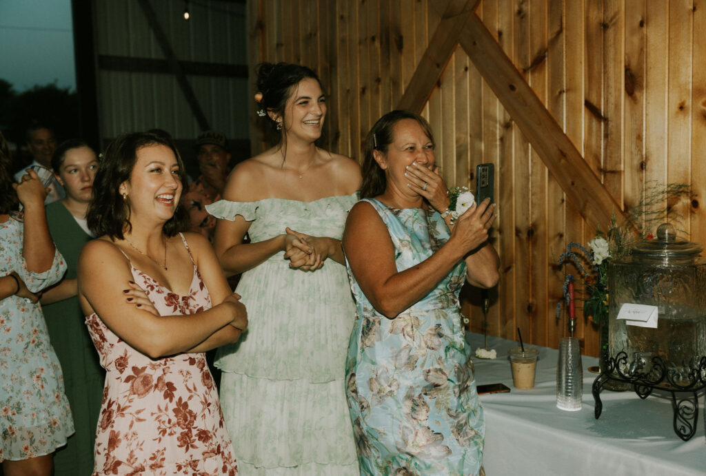 Bride's family recording and laughing at the bride and dad dance.