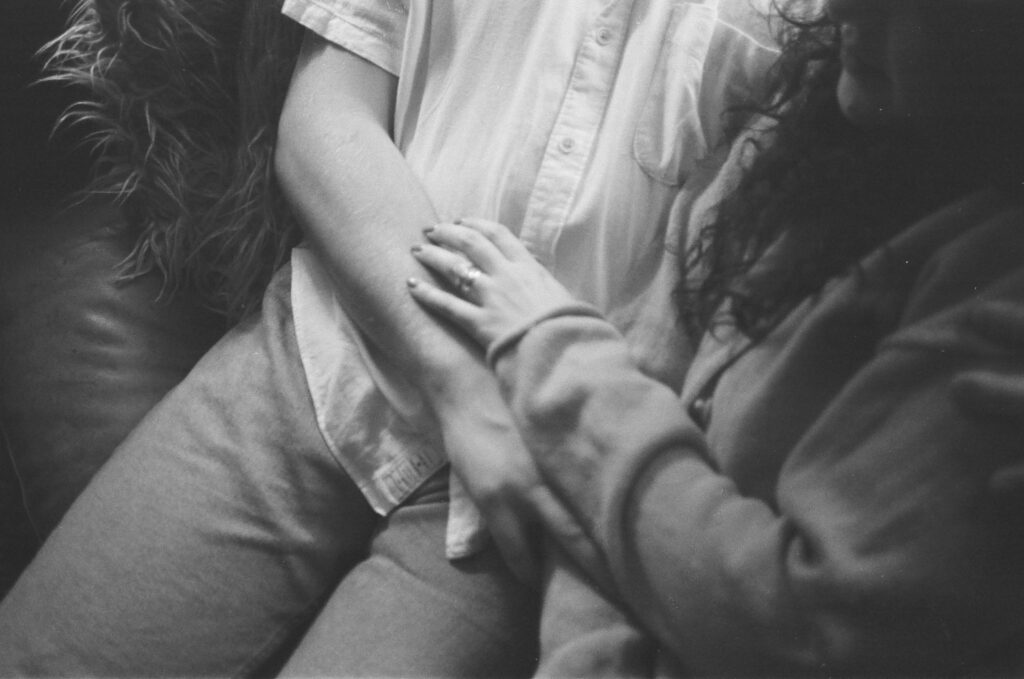 Couple cuddled in the living room of their home by candlelight.