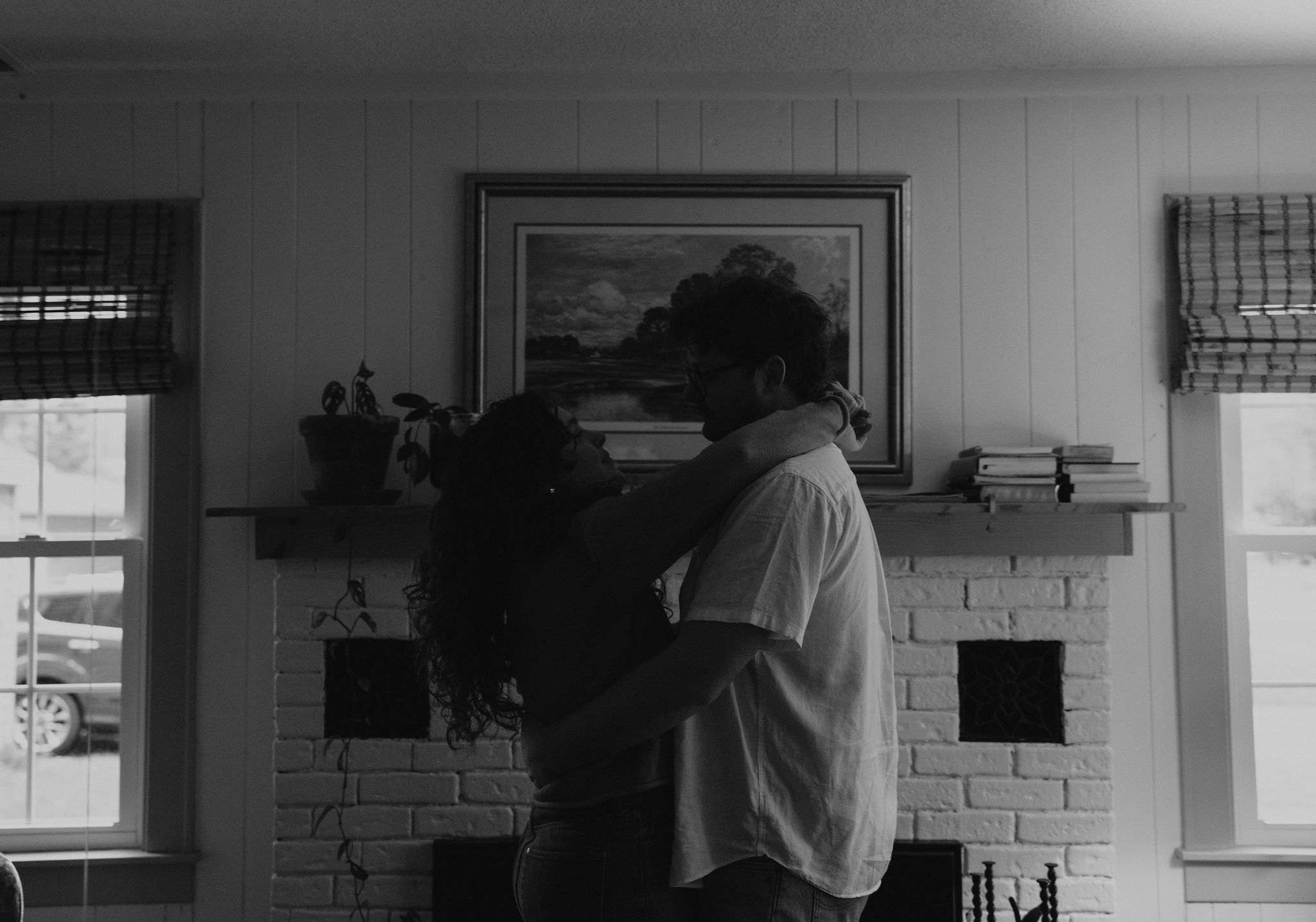 Couple dancing in their living room together at candle light.