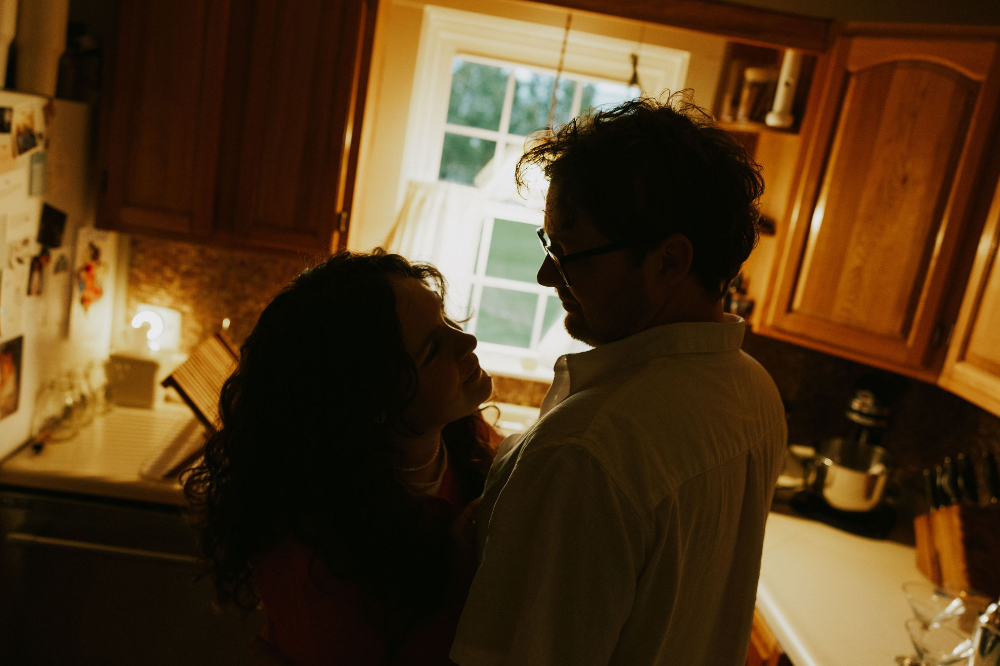 Couple at home dancing in the kitchen light.