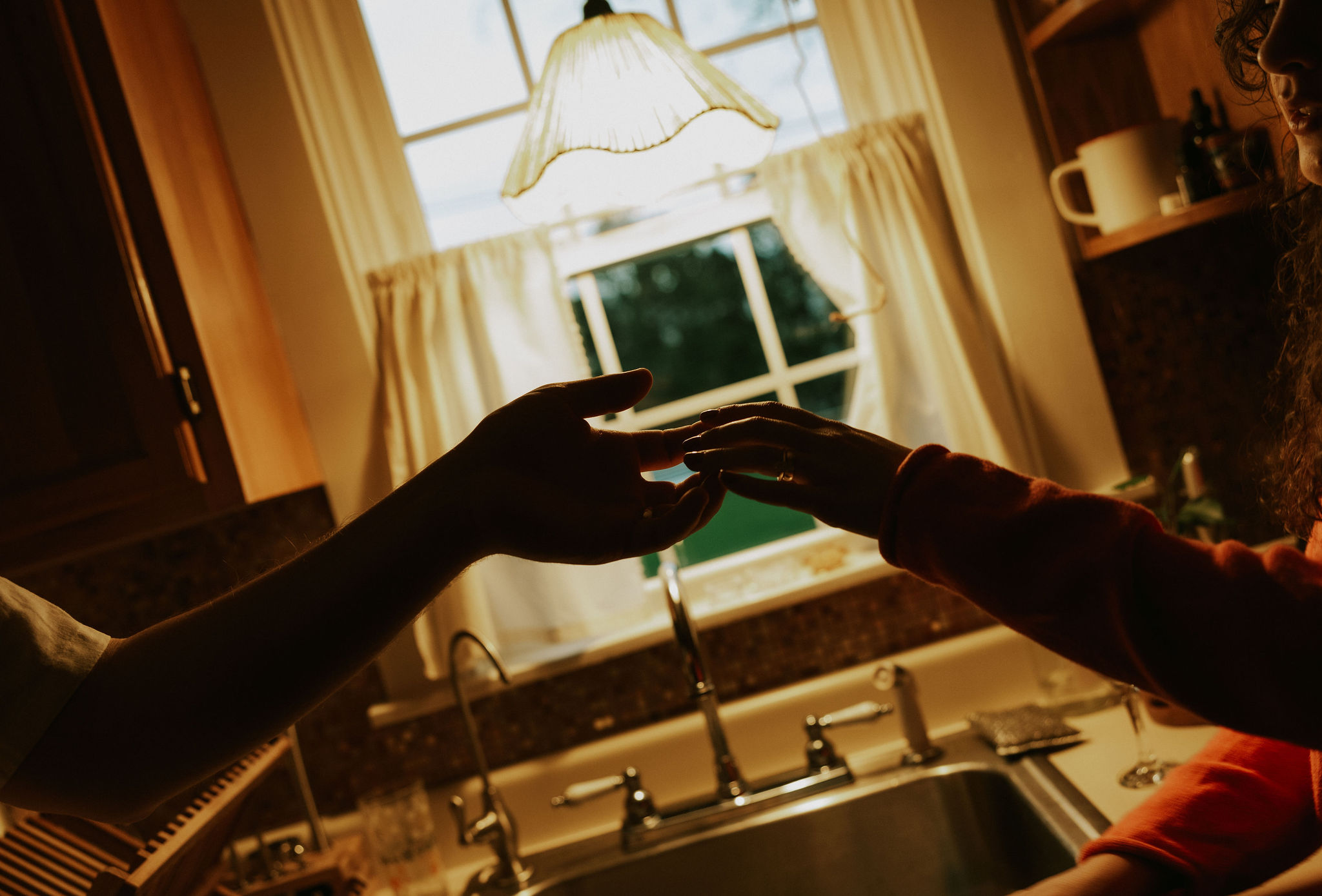 Couple at home dancing in the kitchen light.