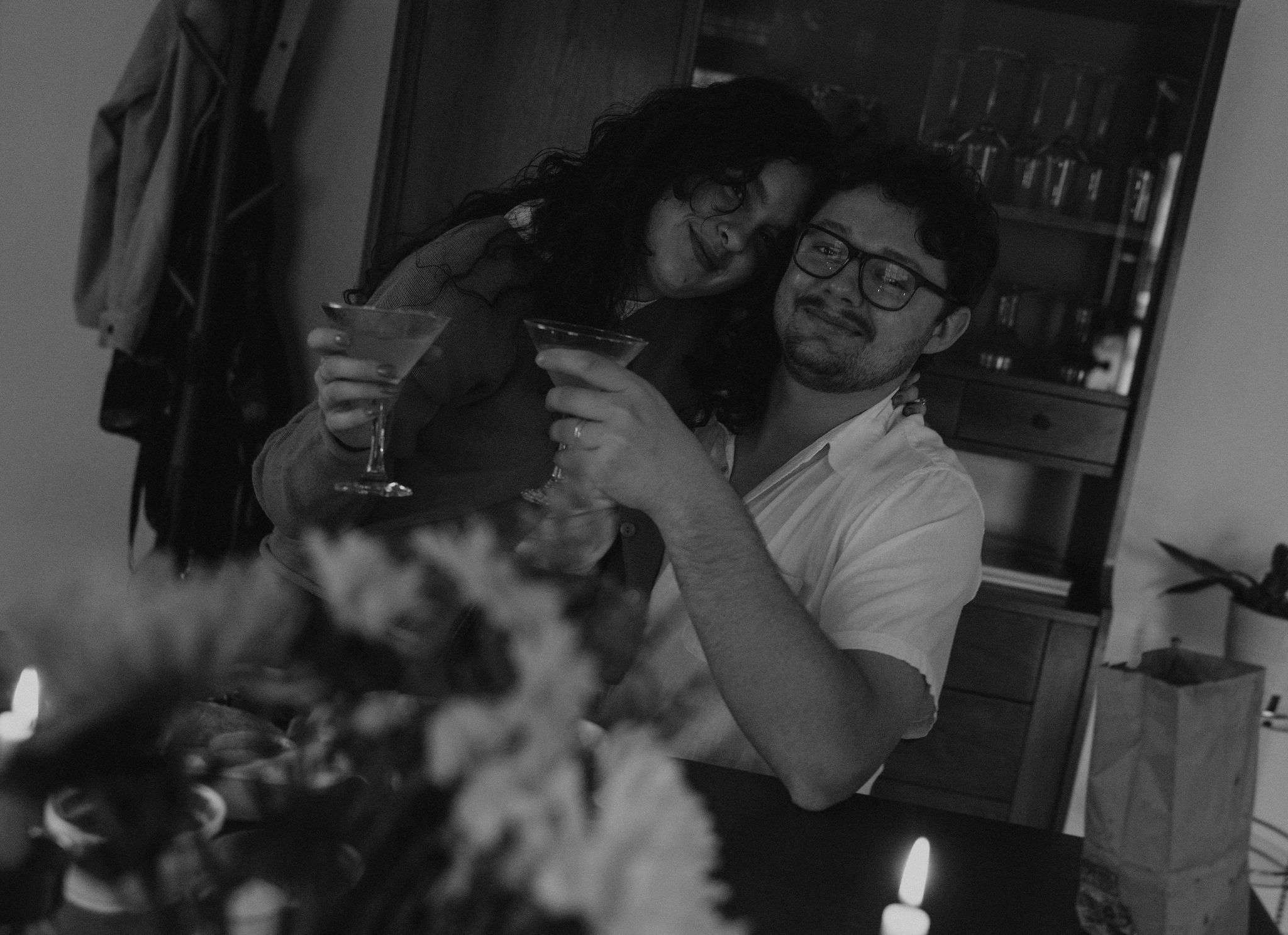 Couple cuddling at kitchen table drinking margaritas.