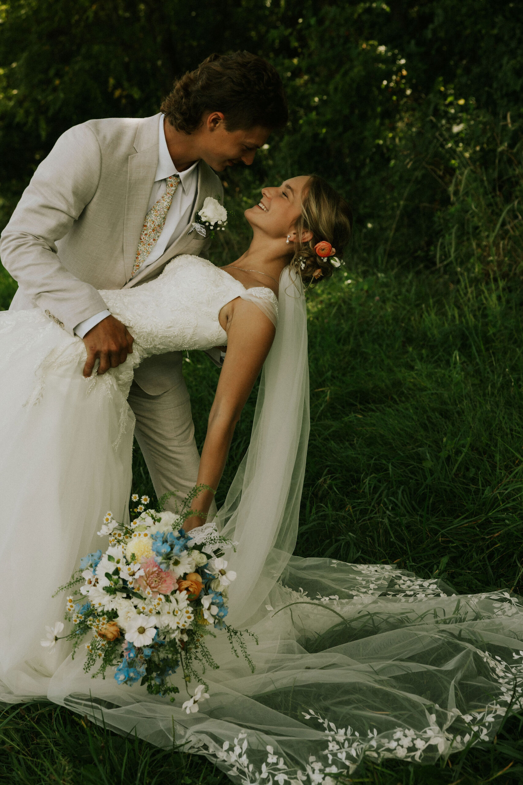 Bride and groom taking portraits together, groom dipping bride.