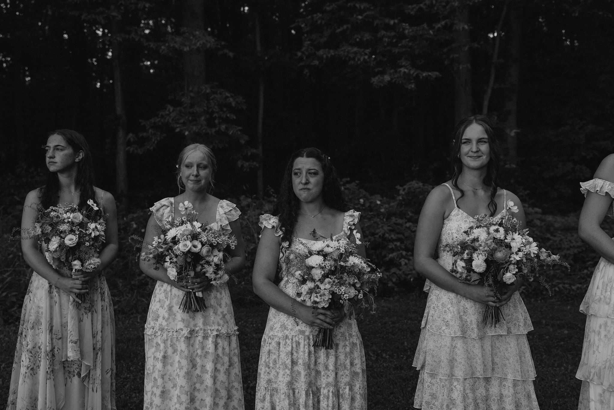 Bridal party members cry tears of joy as the bride walks down the aisle towards the groom.