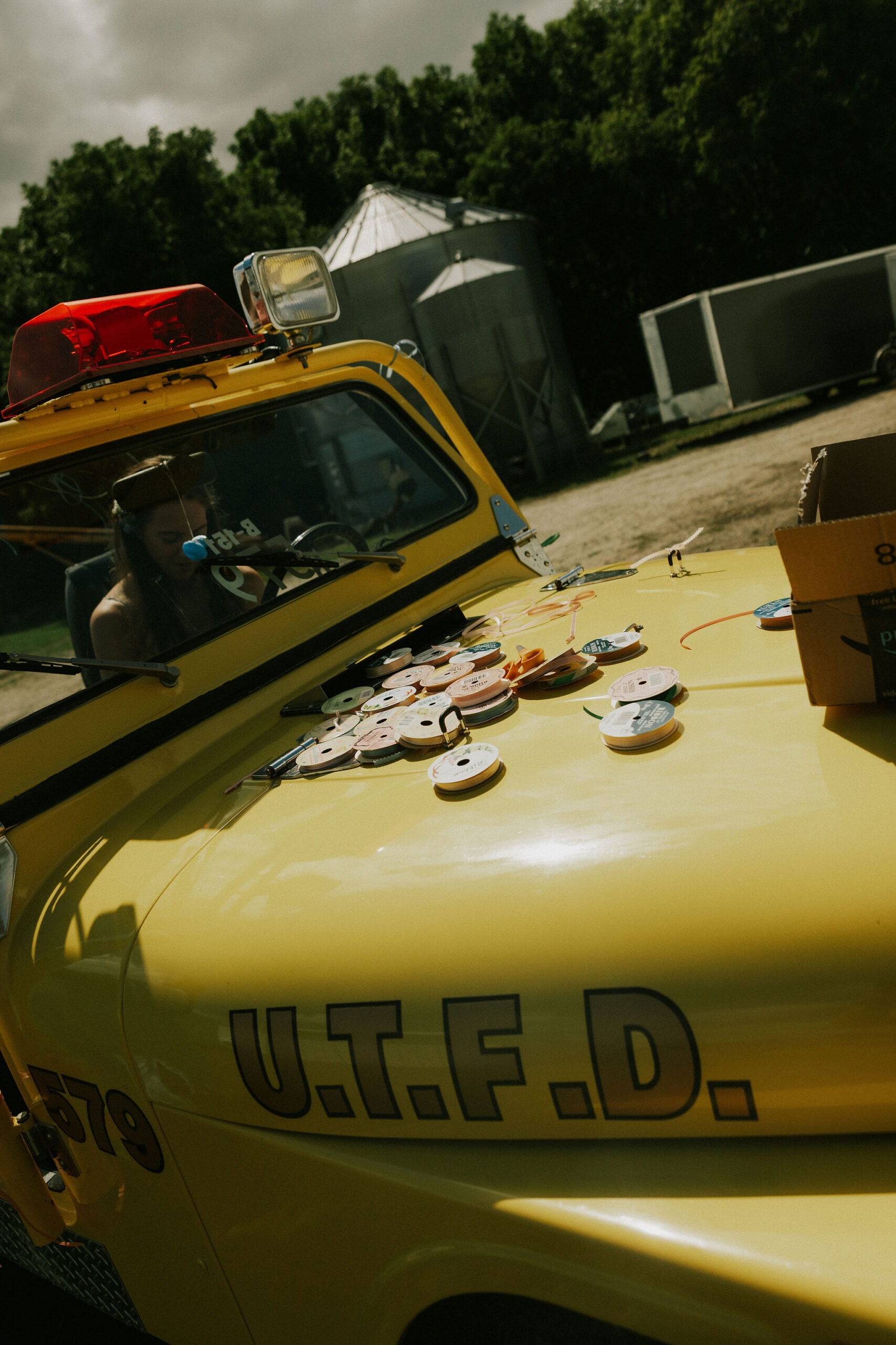 Bridesmaids decorate the getaway Jeep with ribbon for the wedding send off.
