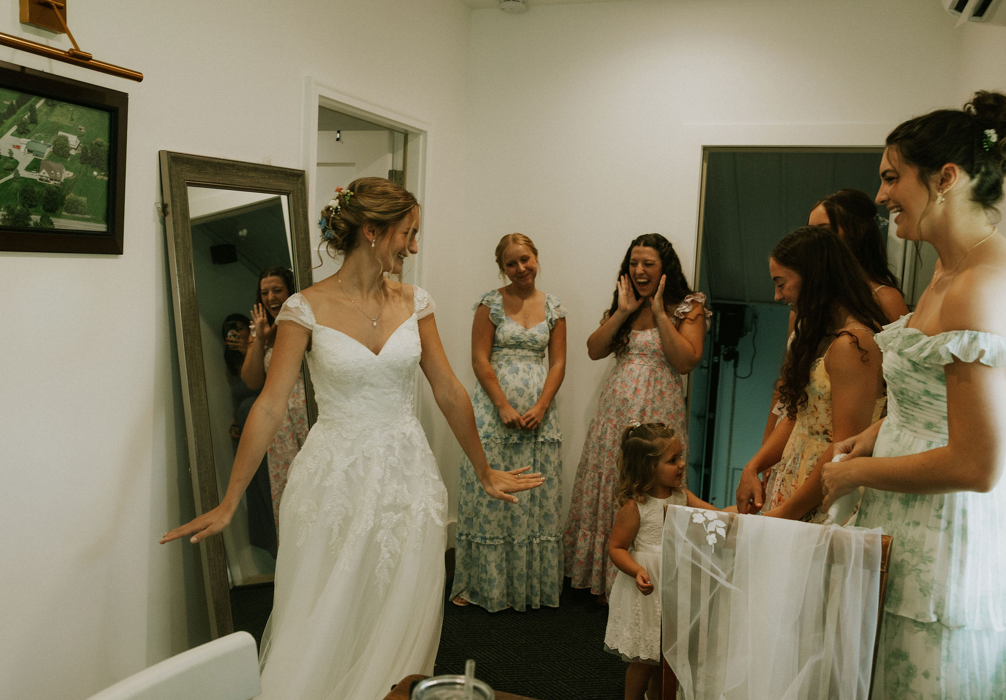 Bridesmaids and flower girl see the bride for the first time after she has finished getting ready.