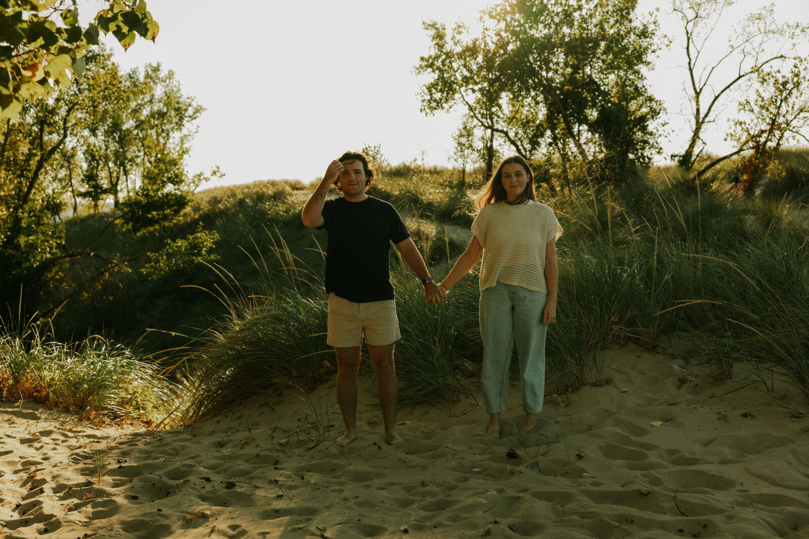 Engaged couple holding hands at Warren Dunes State Park