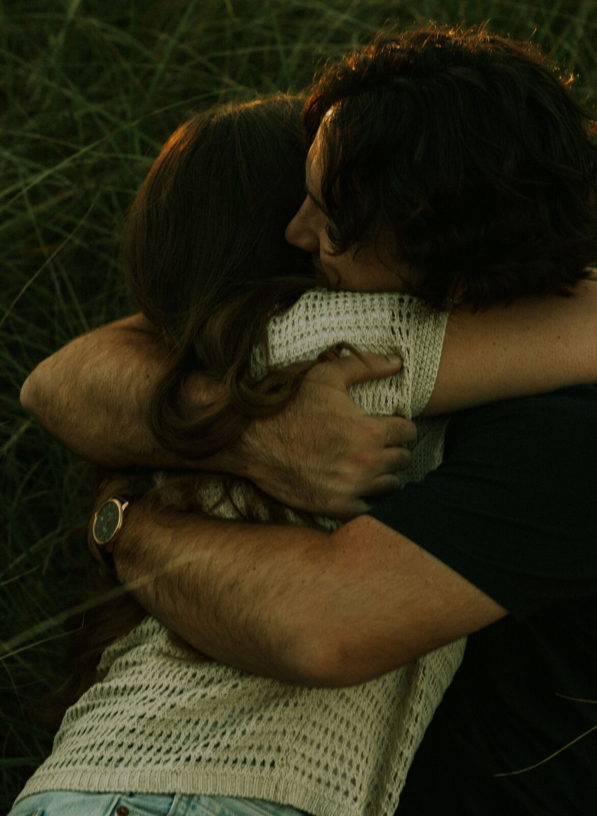 Engaged couple hugging on the dunes at Warren Dunes State Park.