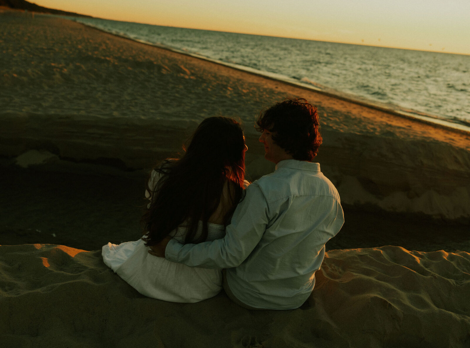Couple sitting on dune at Warren Dunes State Park.