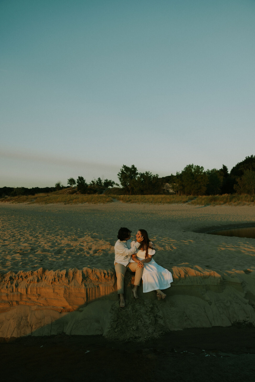 Couple sitting on dune at Warren Dunes State Park.