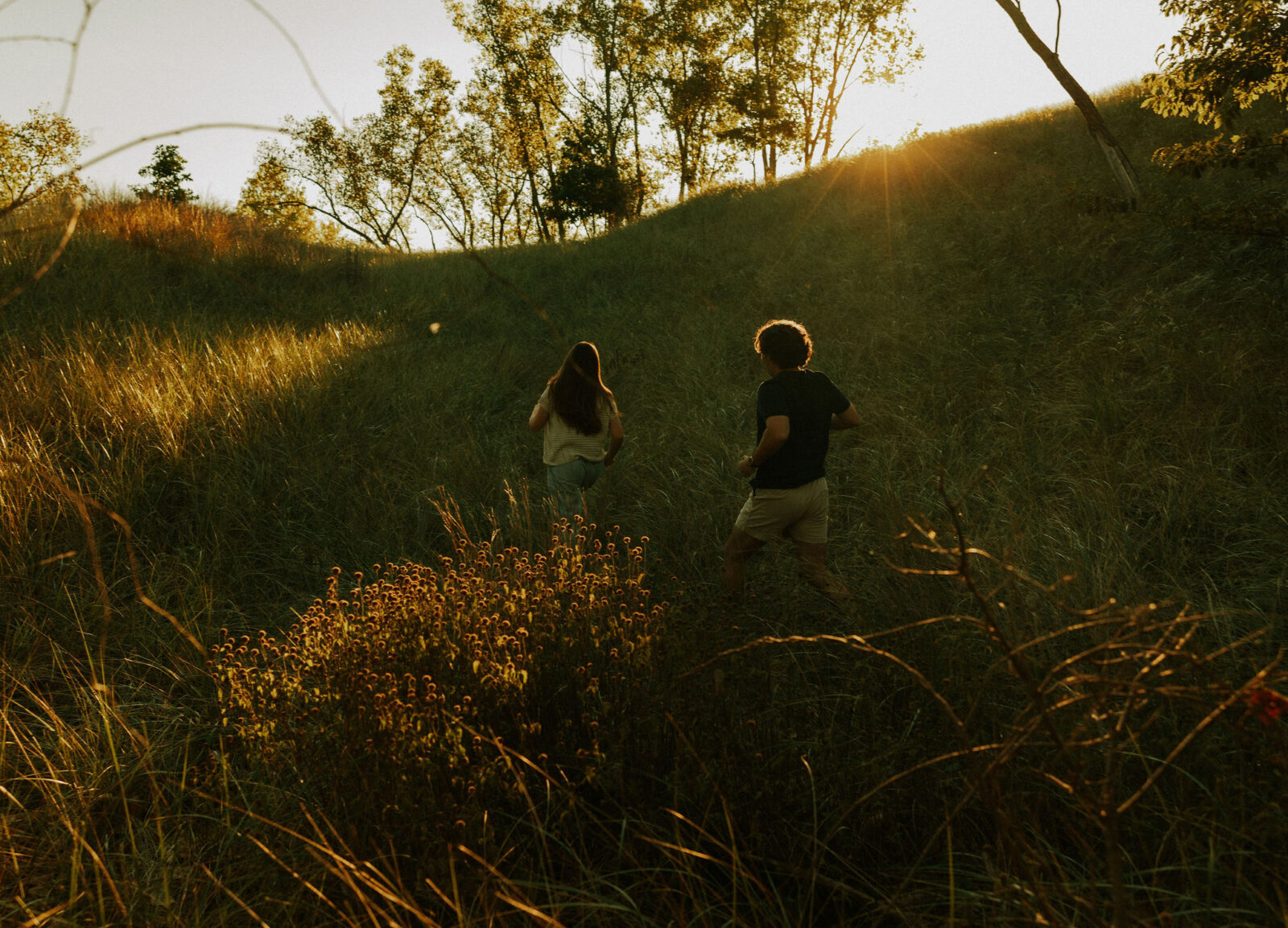 Couple chasing each other through the dunes at Warren dunes state park.