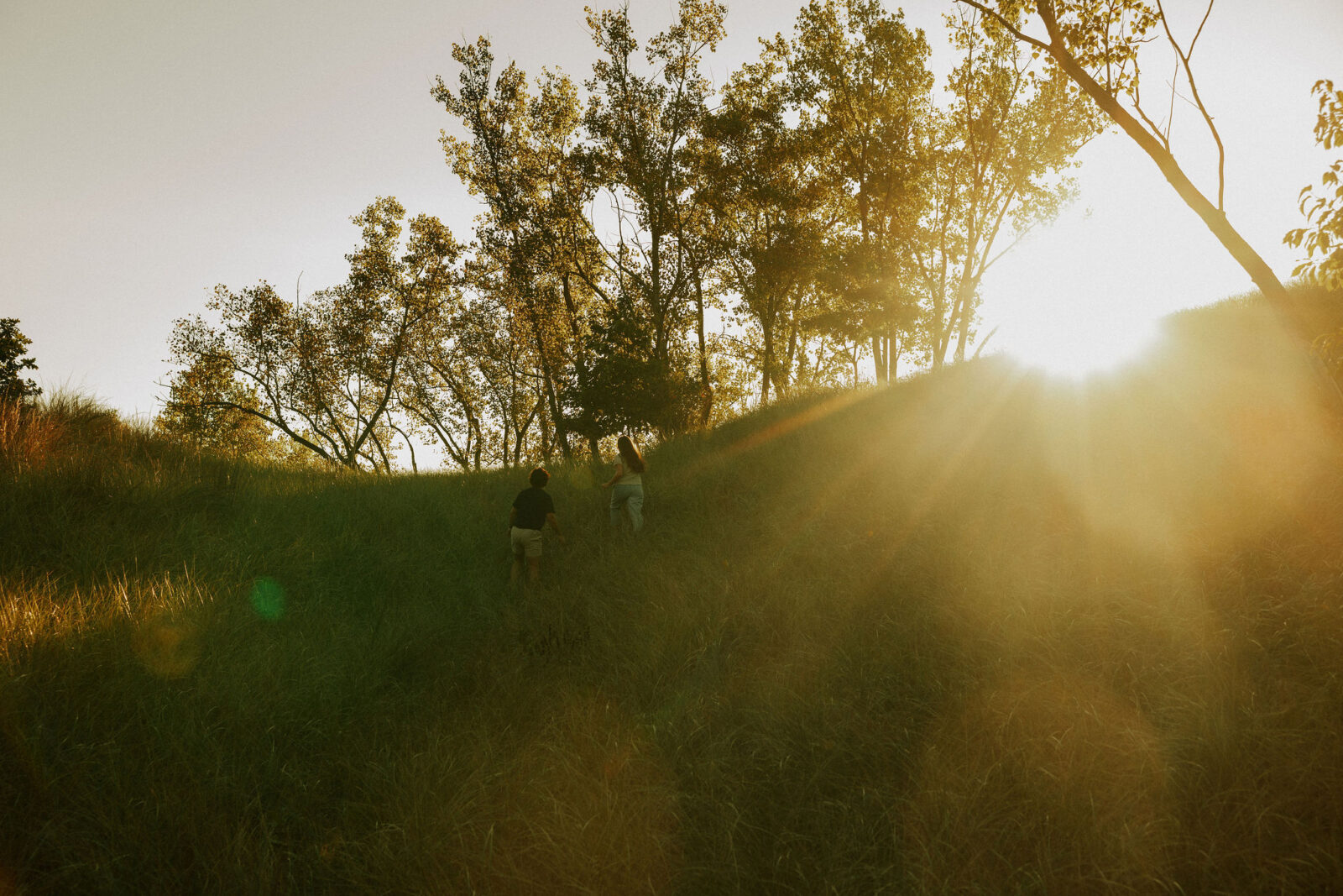 Couple chasing each other through the dunes at Warren dunes state park.