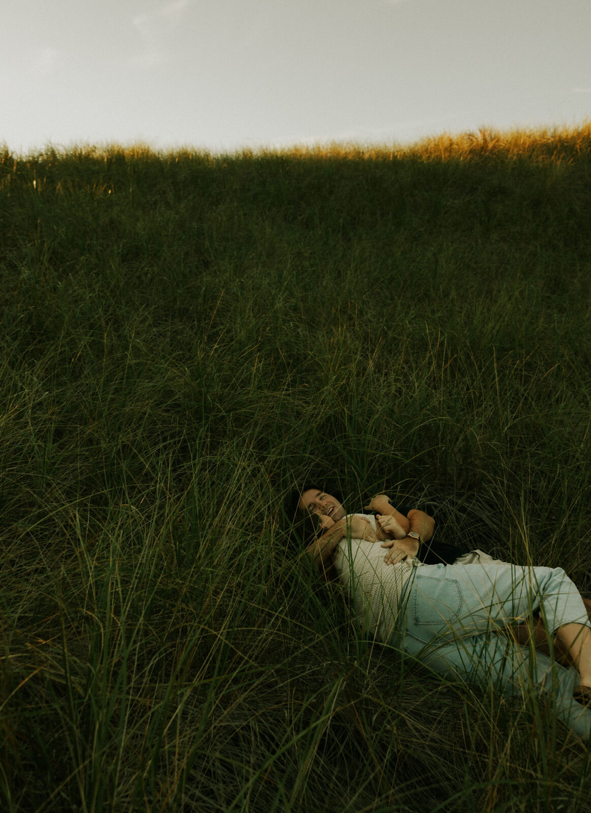 Couple cuddling on the beach at Warren Dunes State Park.