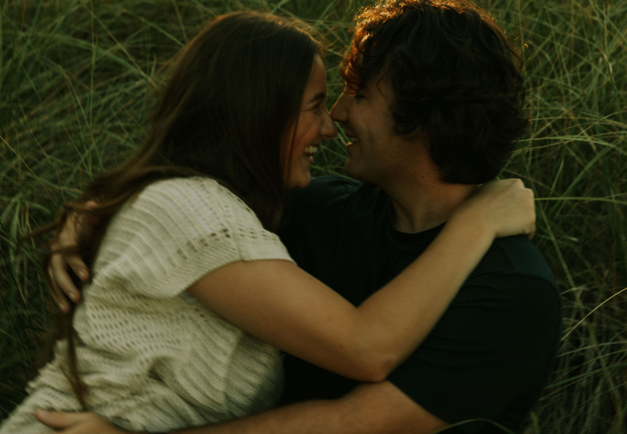 Couple cuddling on the beach at Warren Dunes State Park.